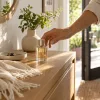 Hand reaching for a perfume bottle beside house keys before leaving home